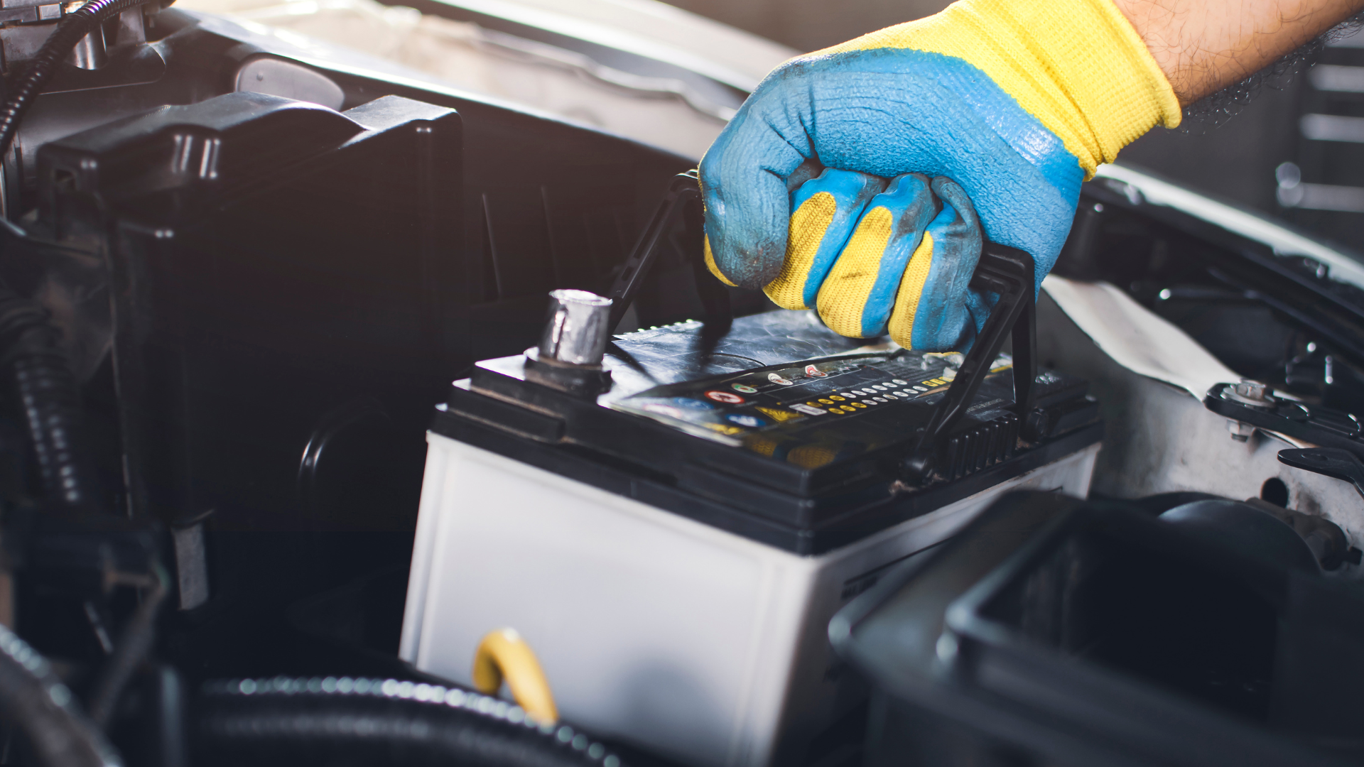A person is holding a car battery in their hand.