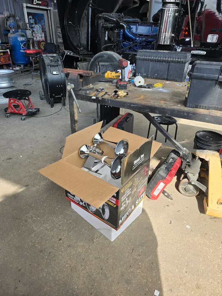 A box of parts is sitting on top of a table in a garage.