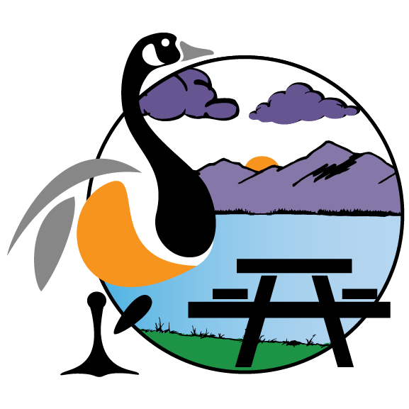 Stylized black and orange bird beside a picnic table, with mountains, clouds, and a sunset in a circle background
