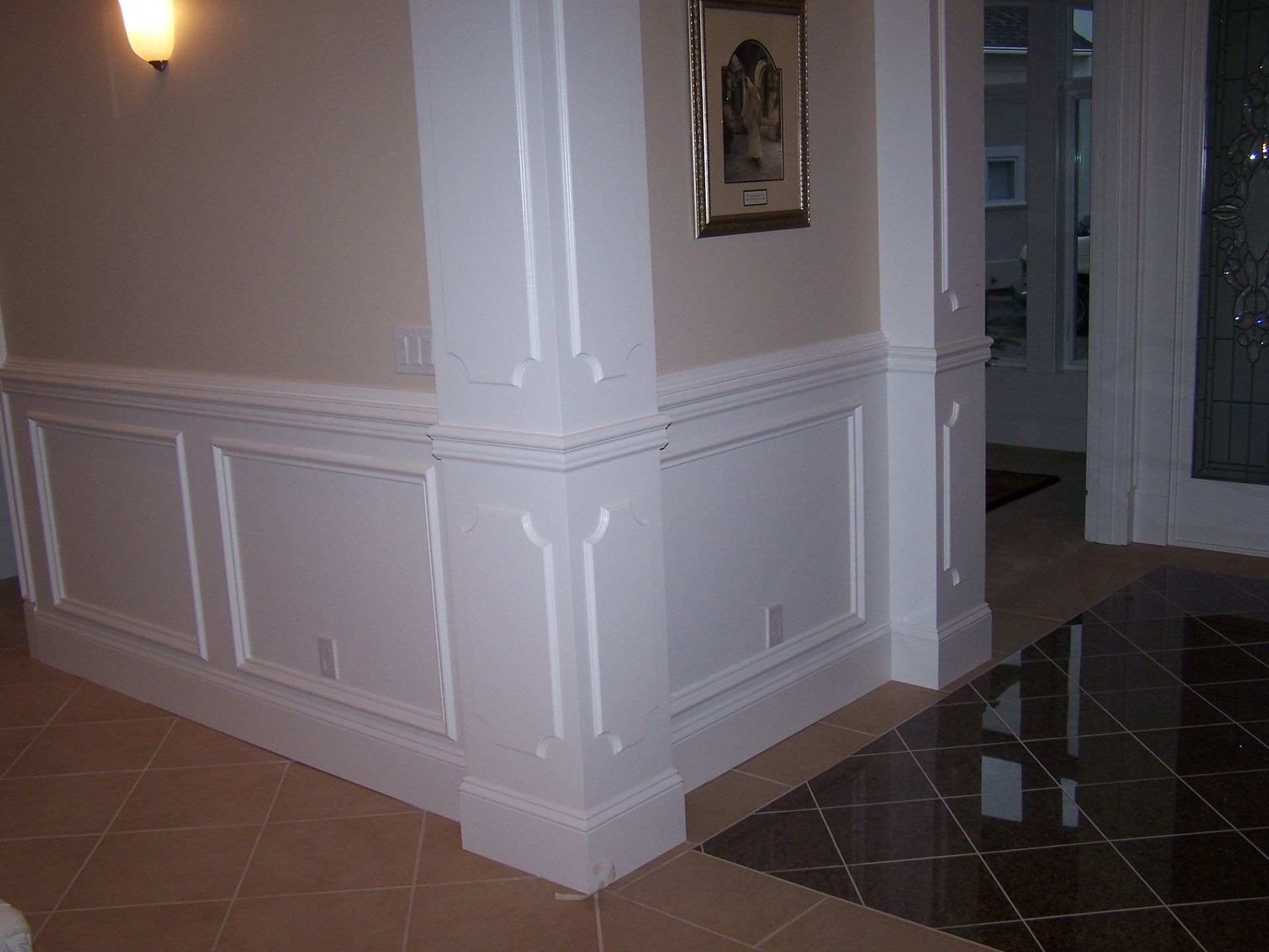 A hallway with white trim and a picture on the wall