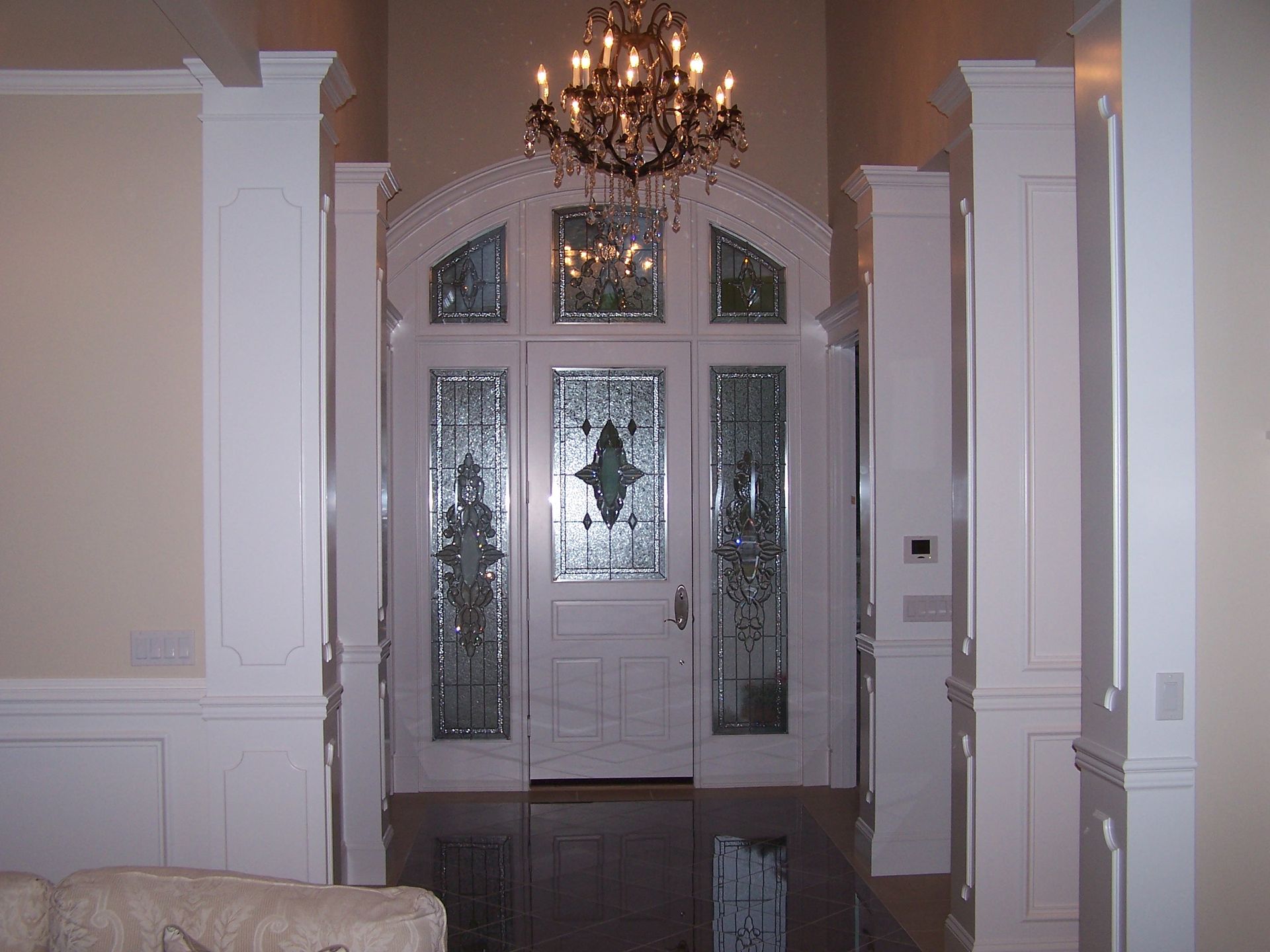 A living room with a couch and a chandelier above the door