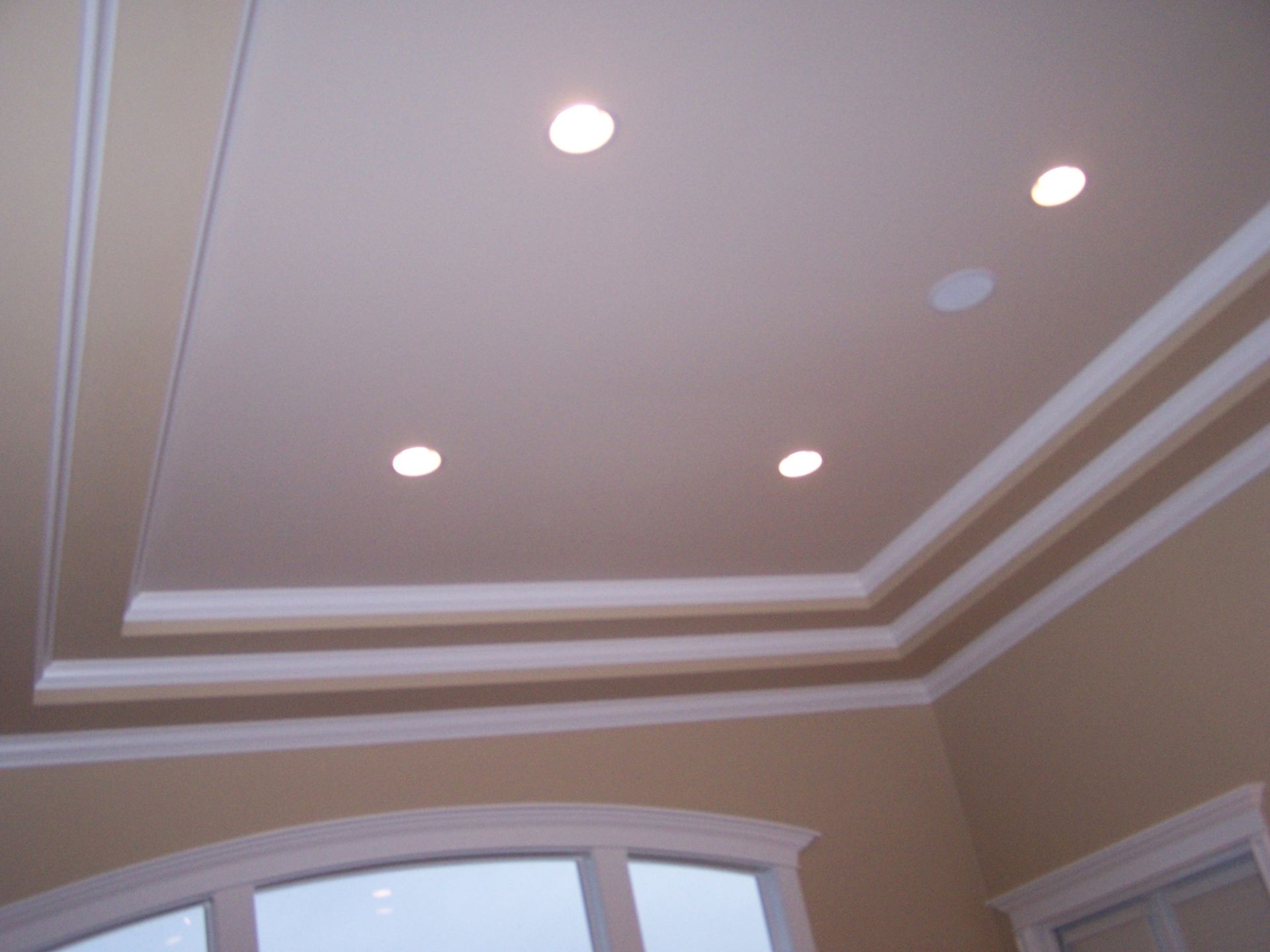 A room with a ceiling that has three lights on it