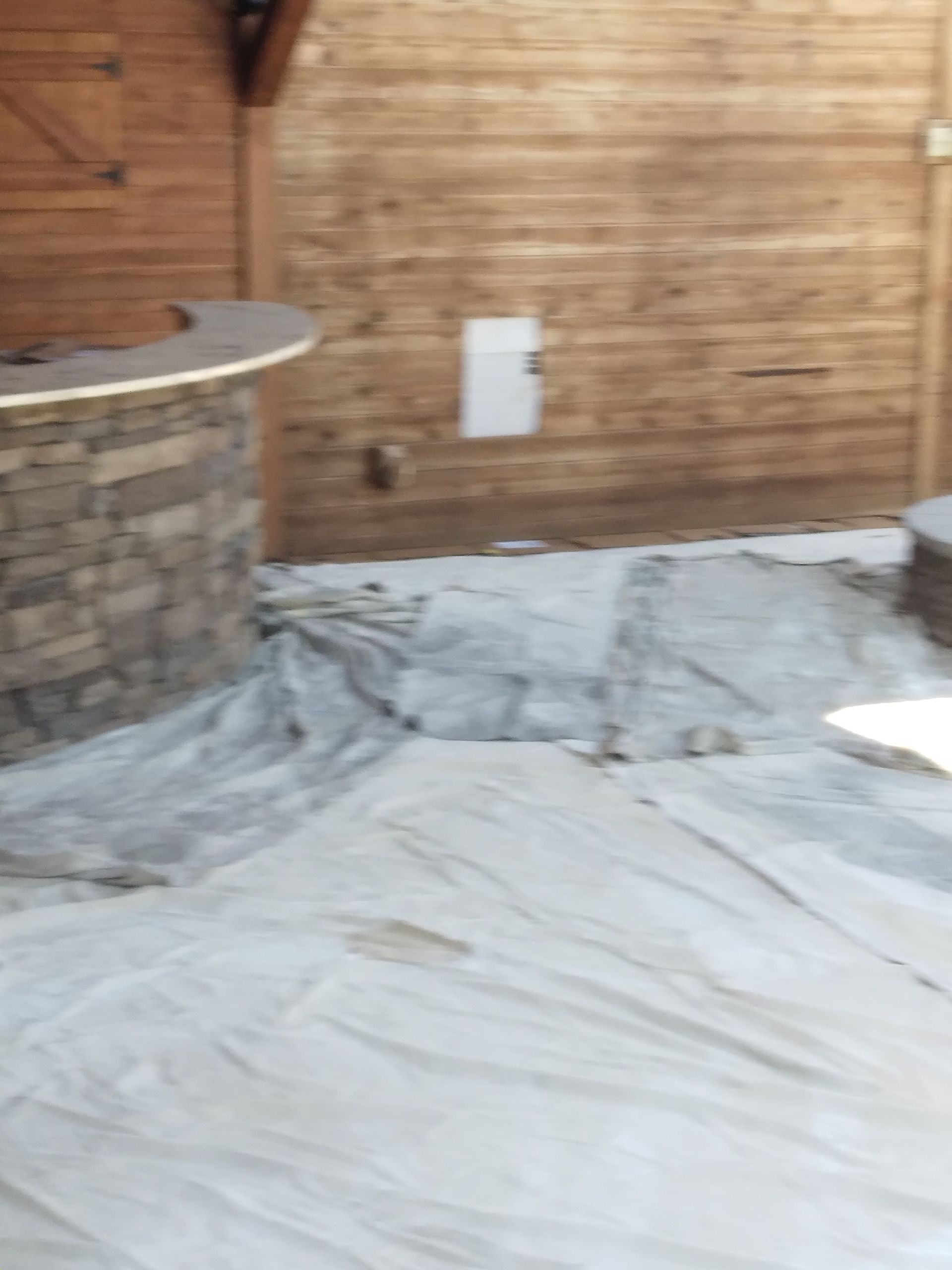 An empty room with a wooden wall and a stone bar