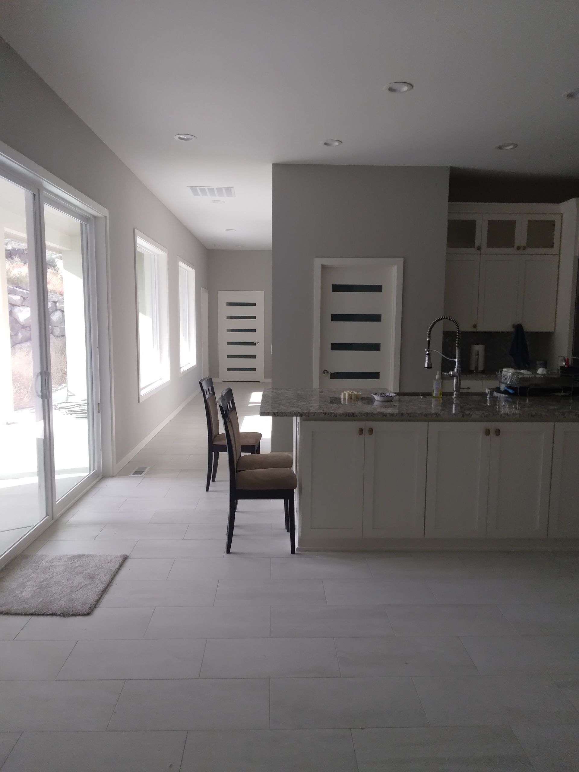 A kitchen with white cabinets and granite counter tops