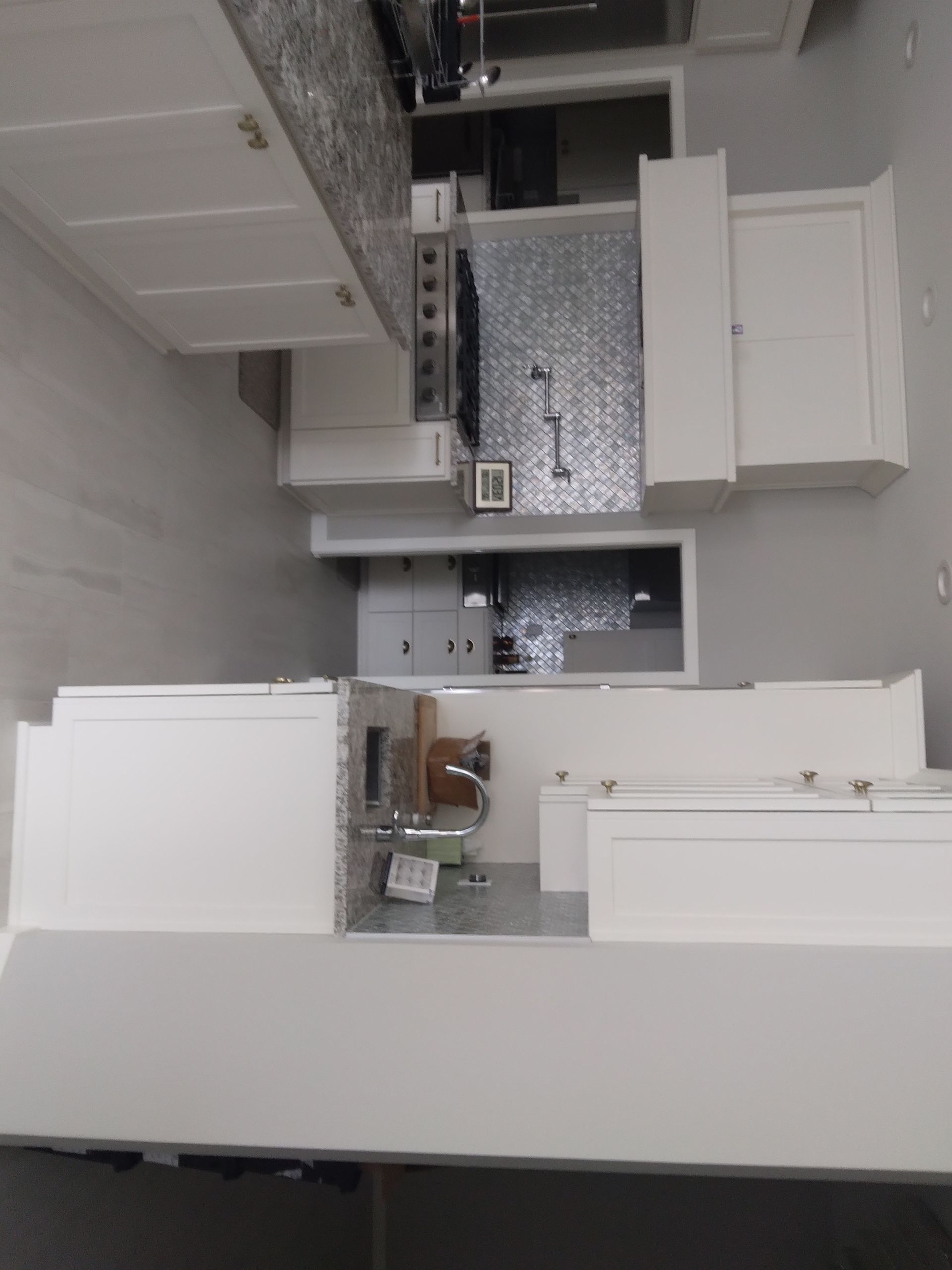 A kitchen with white cabinets and a sink.