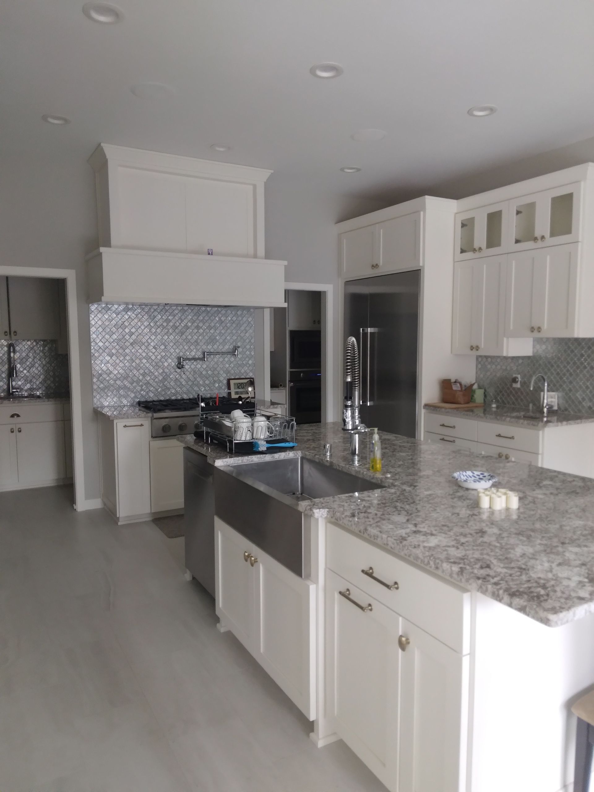 A kitchen with white cabinets and granite counter tops