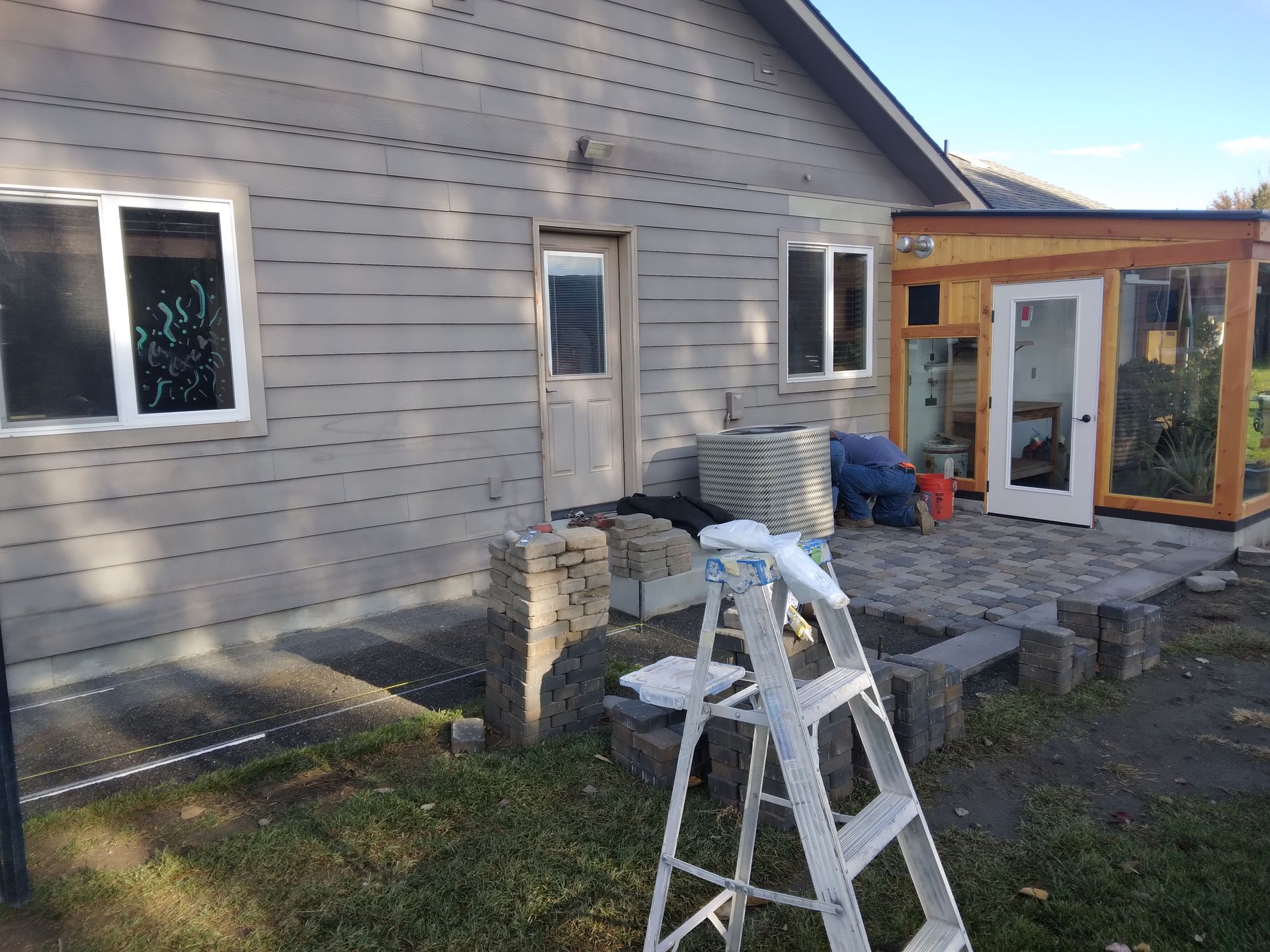 A white ladder is sitting in front of a house