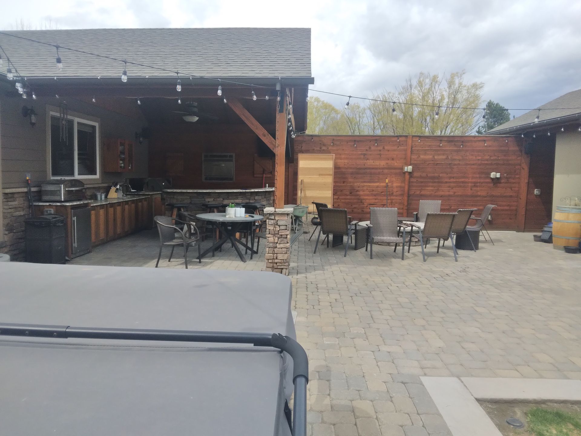 A patio with a table and chairs and a hot tub.