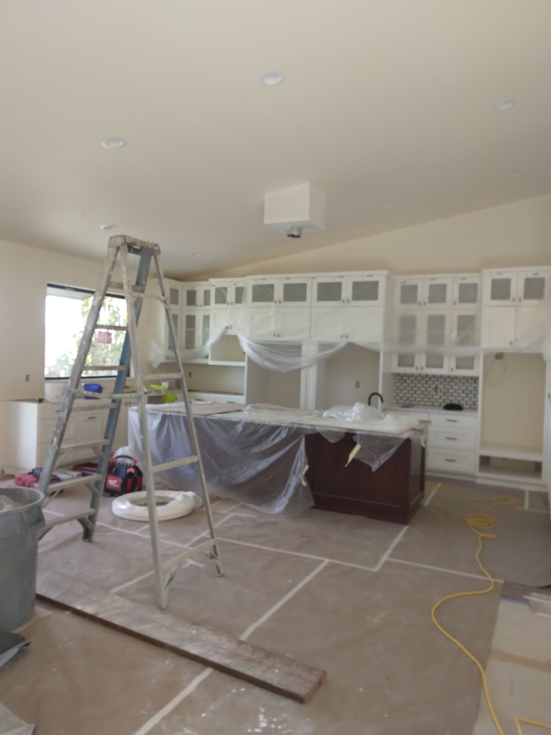 A kitchen under construction with a ladder on the floor