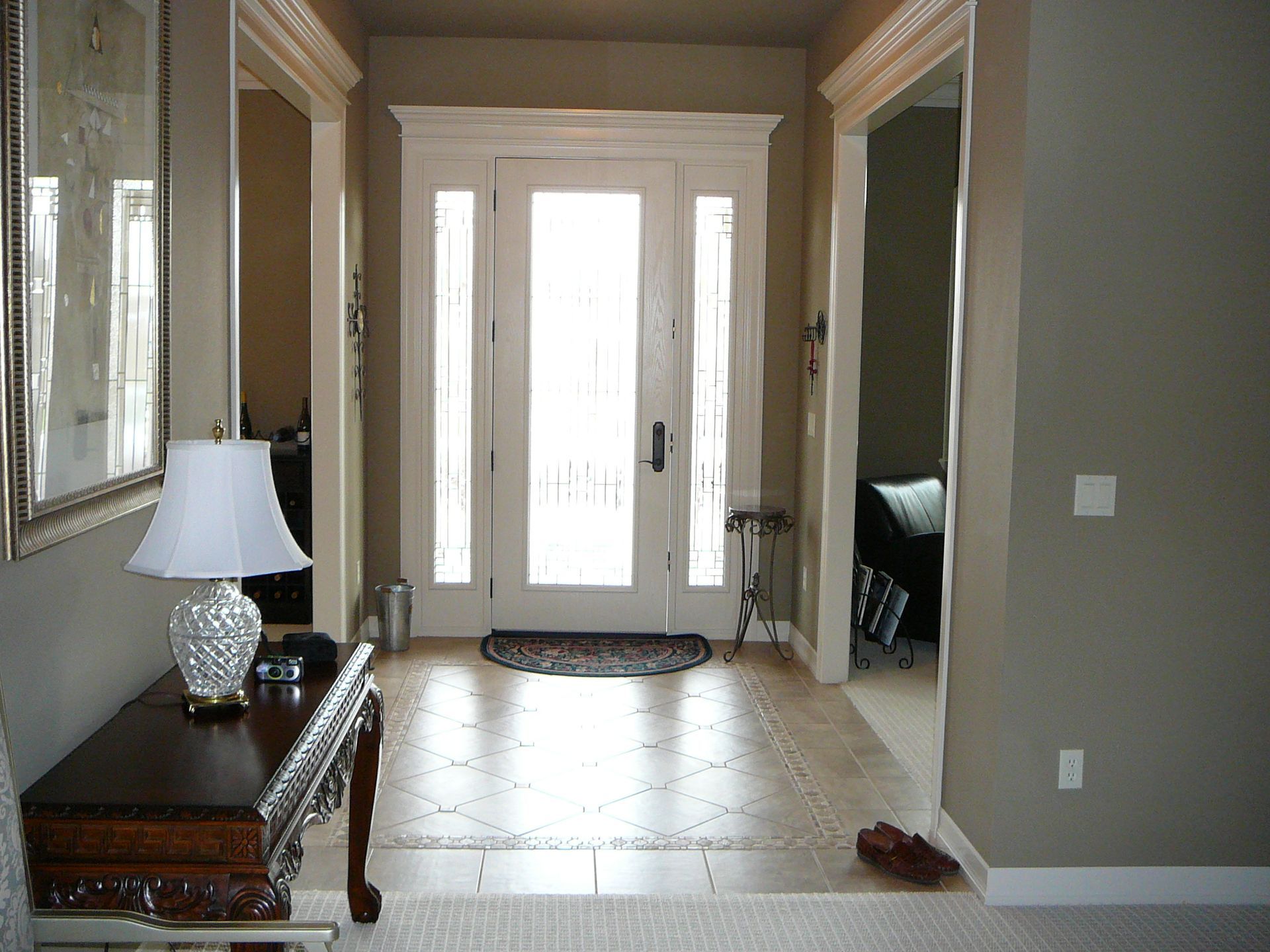 A hallway with a table and a lamp in it