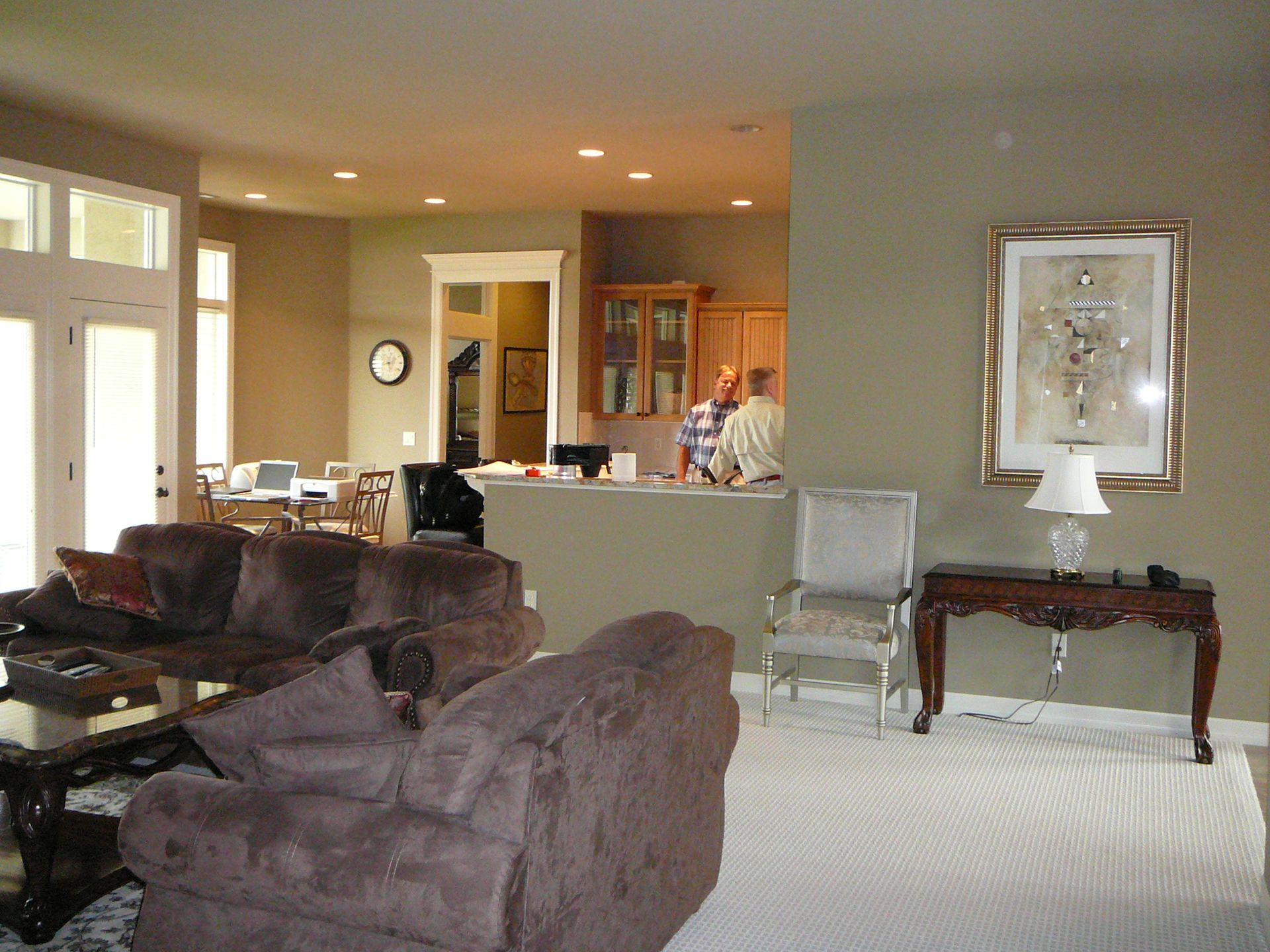 A living room with brown furniture and a picture on the wall