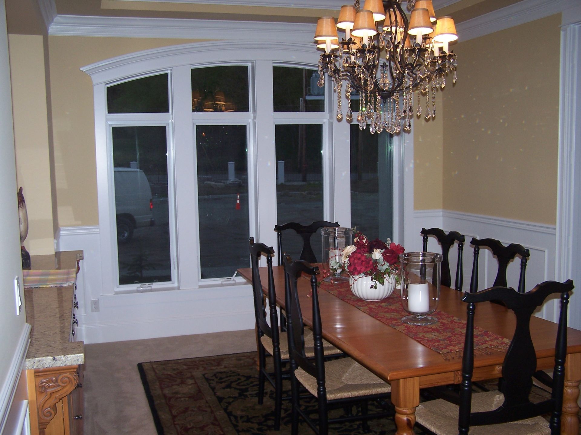 A dining room with a table and chairs and a chandelier