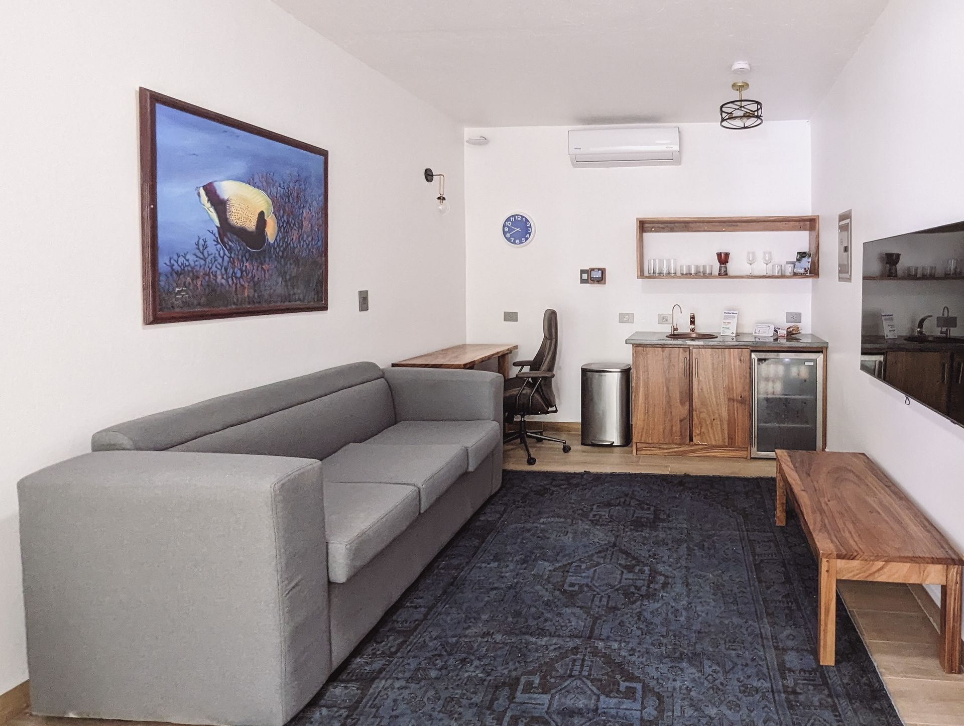 A living room with a couch and a picture on the wall