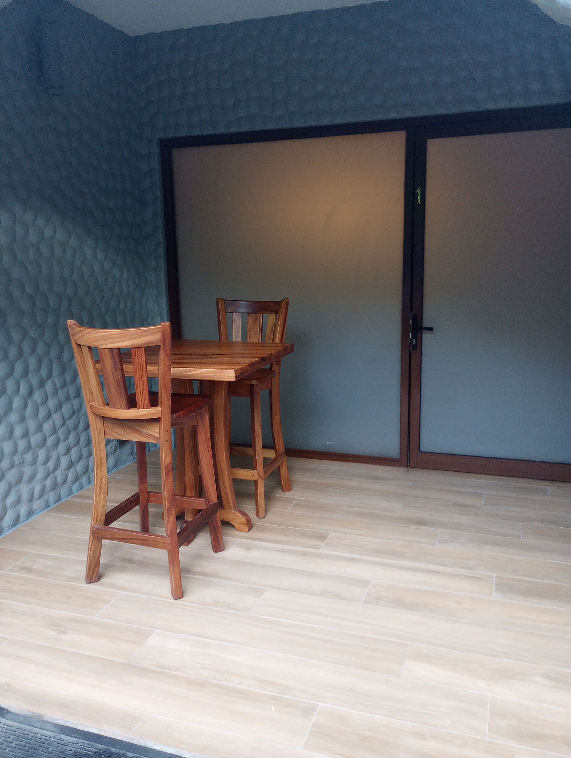 A wooden table and chairs are sitting on a wooden floor in a room.