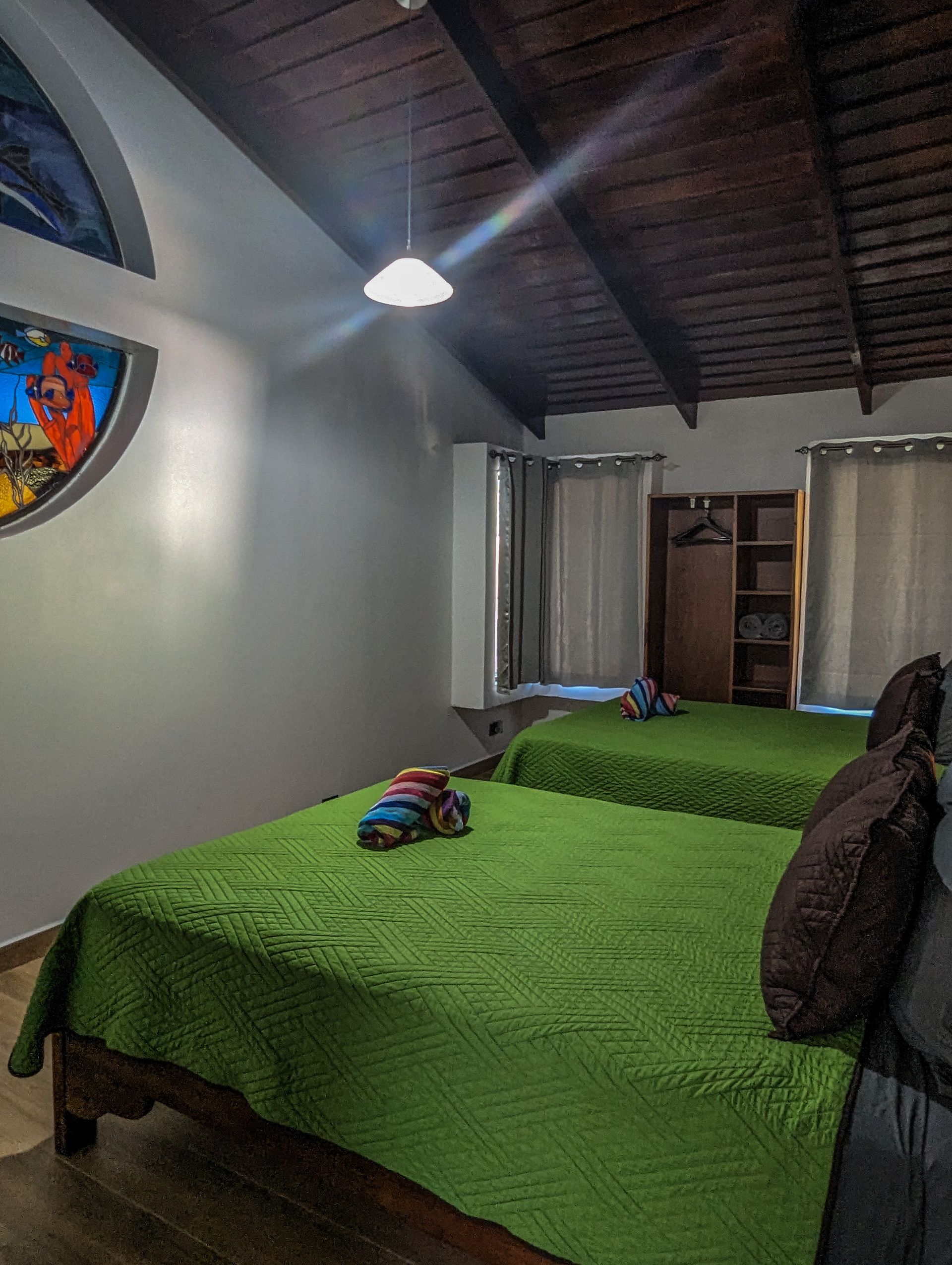 A bedroom with two beds and a painting on the wall.