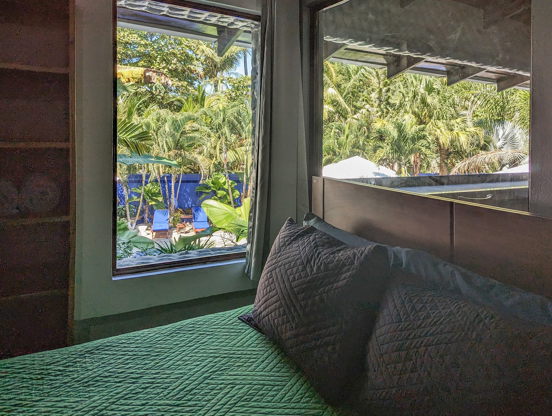 A bedroom with a bed and a window with a view of trees.