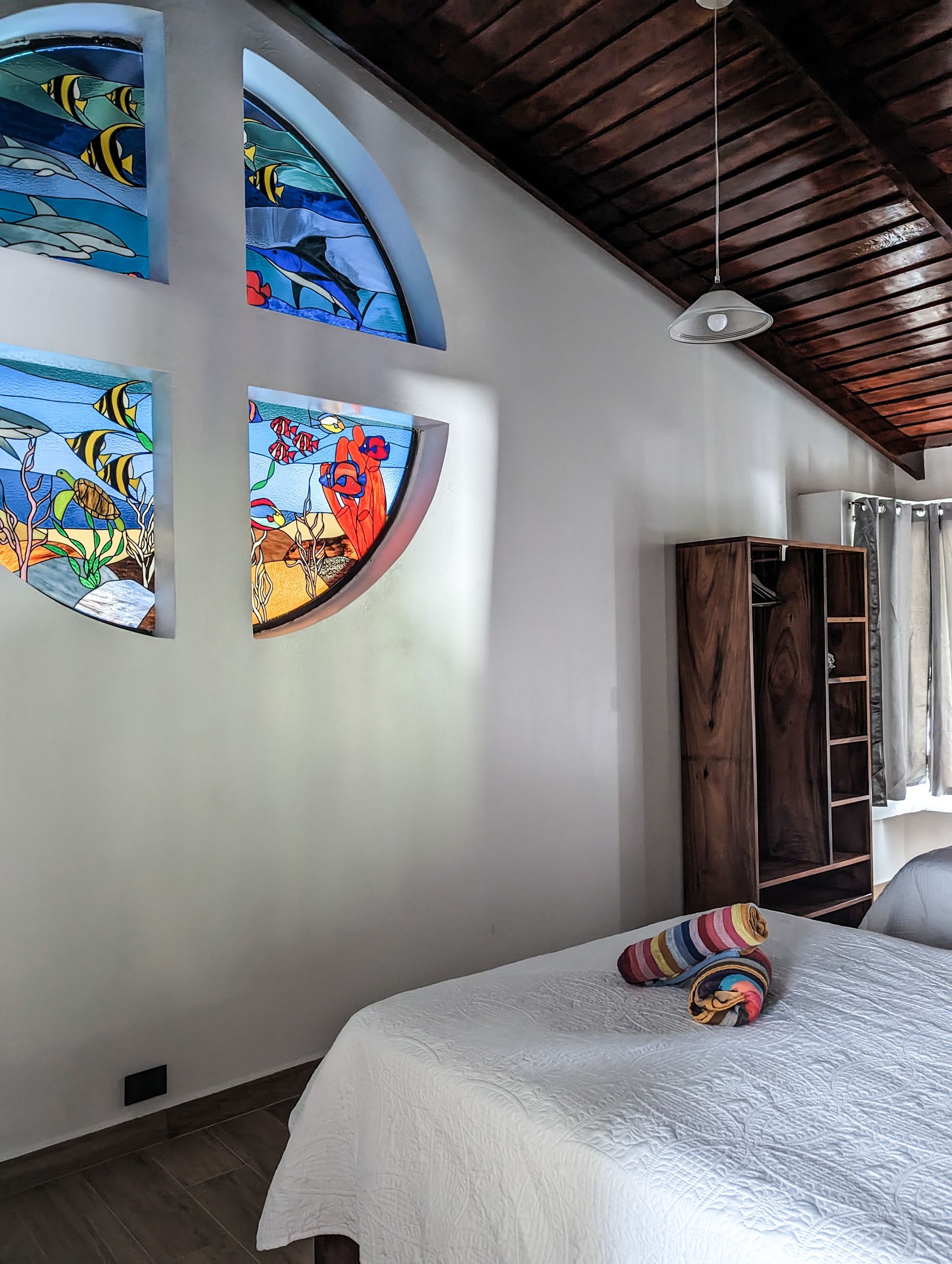 A bedroom with a bed and stained glass windows