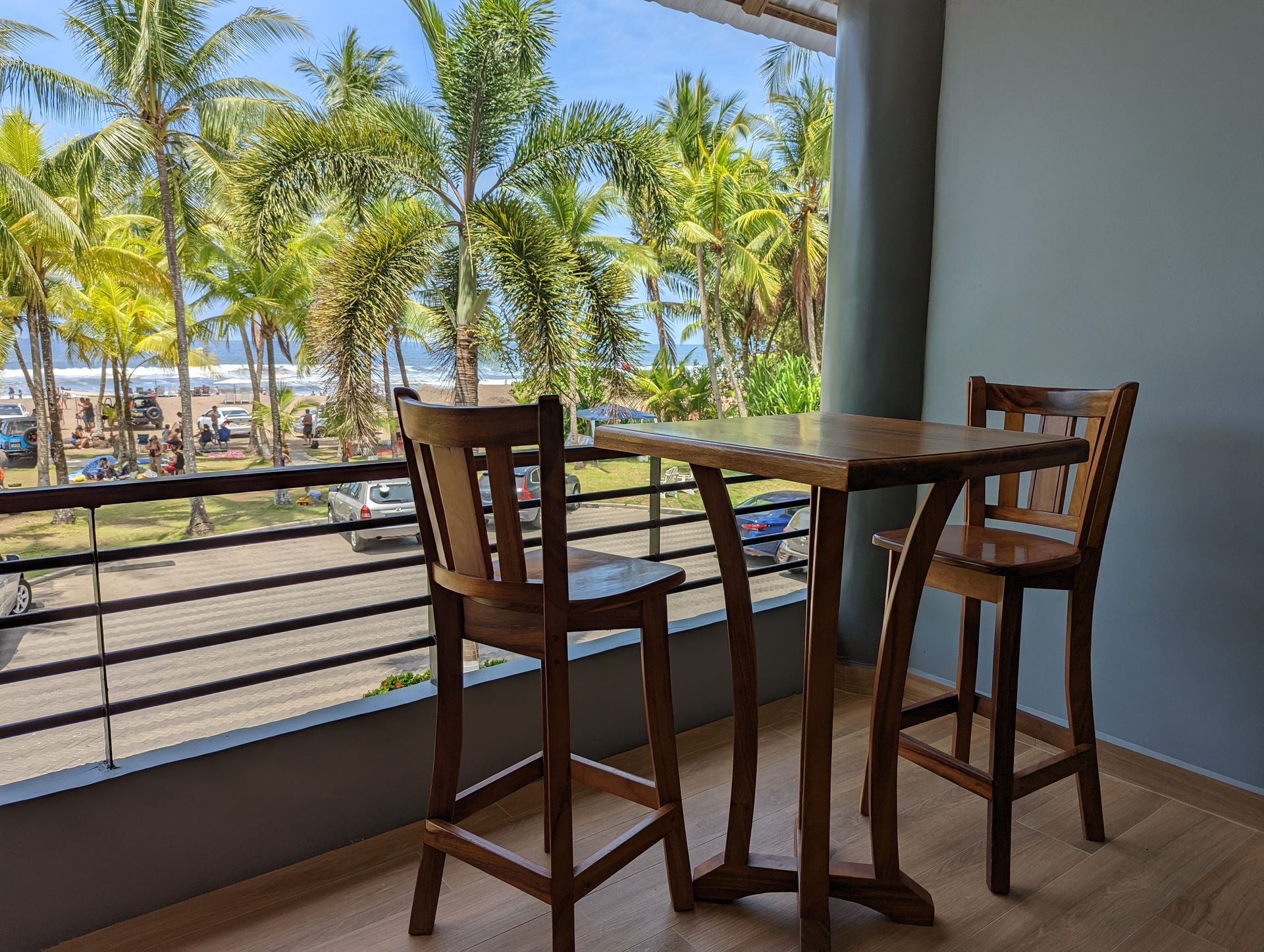 A balcony with a table and chairs and a view of the ocean.