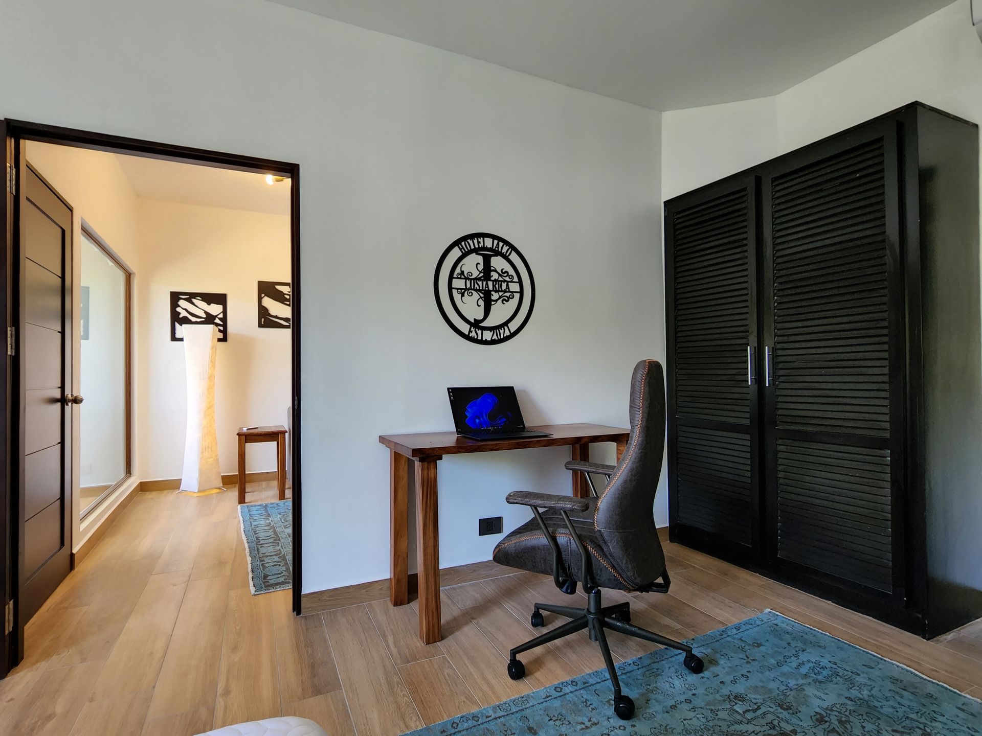 A room with a desk and chair and a laptop on it.