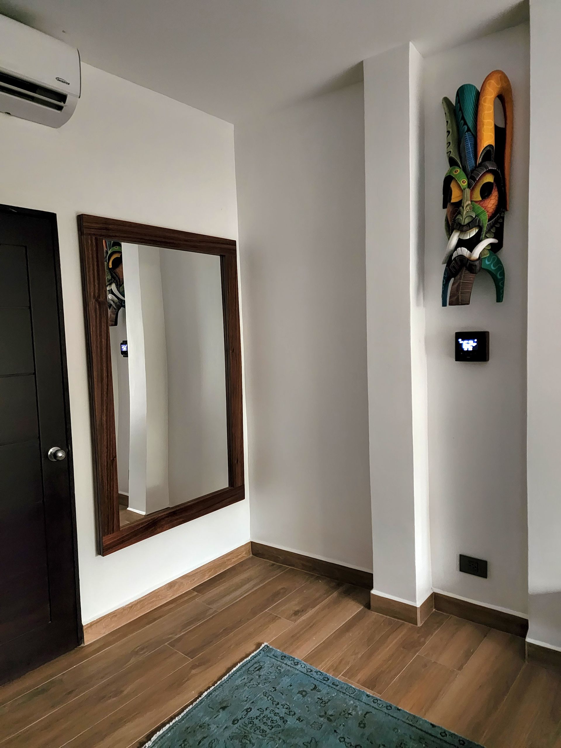 A room with a large mirror and a statue on the wall.