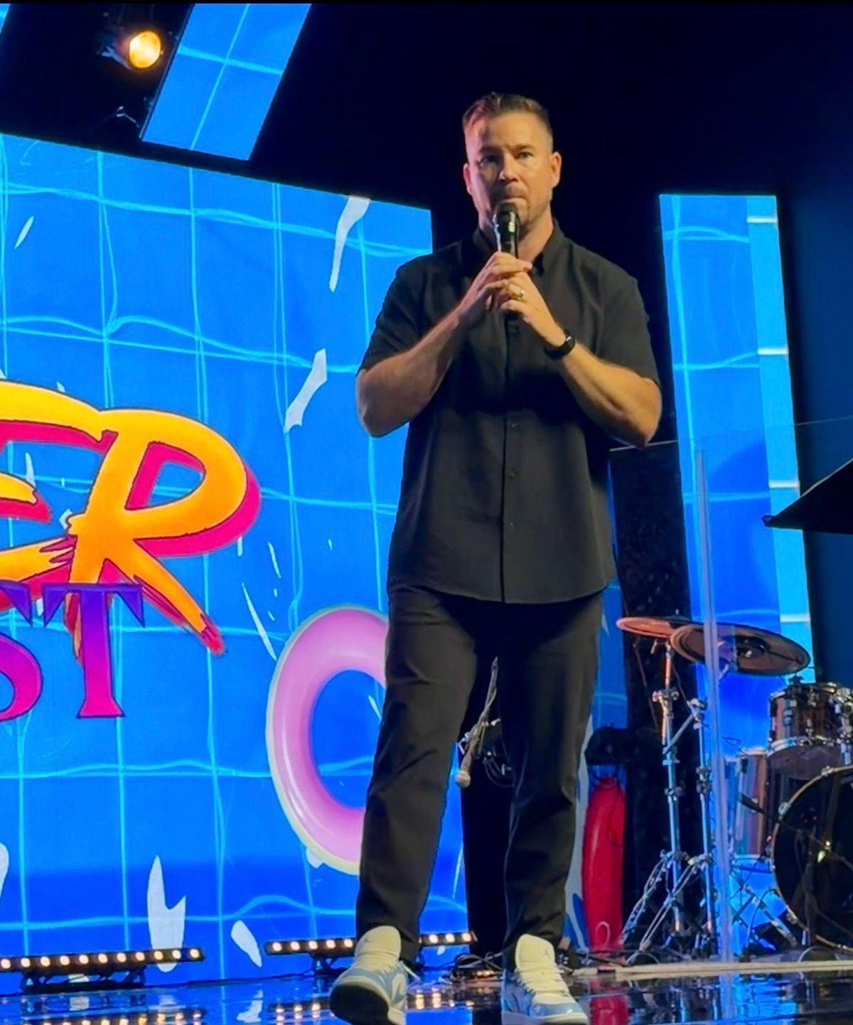 Chad Galbreath speaking on a stage with a colorful backdrop