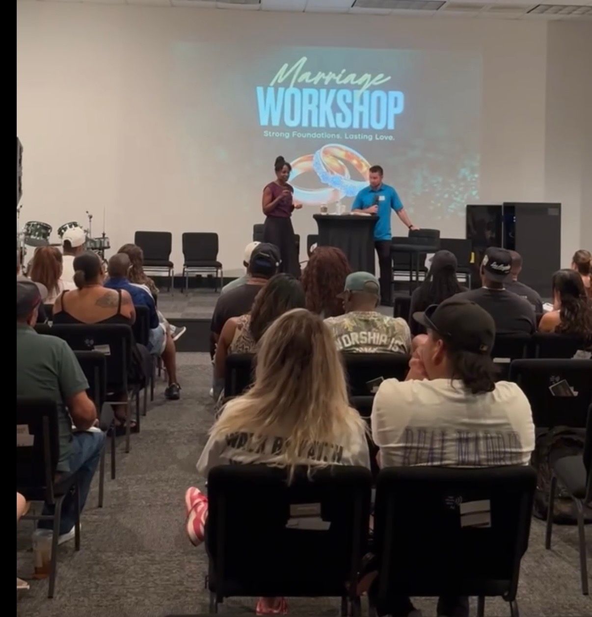 A marriage workshop with couples seated at tables facing the front