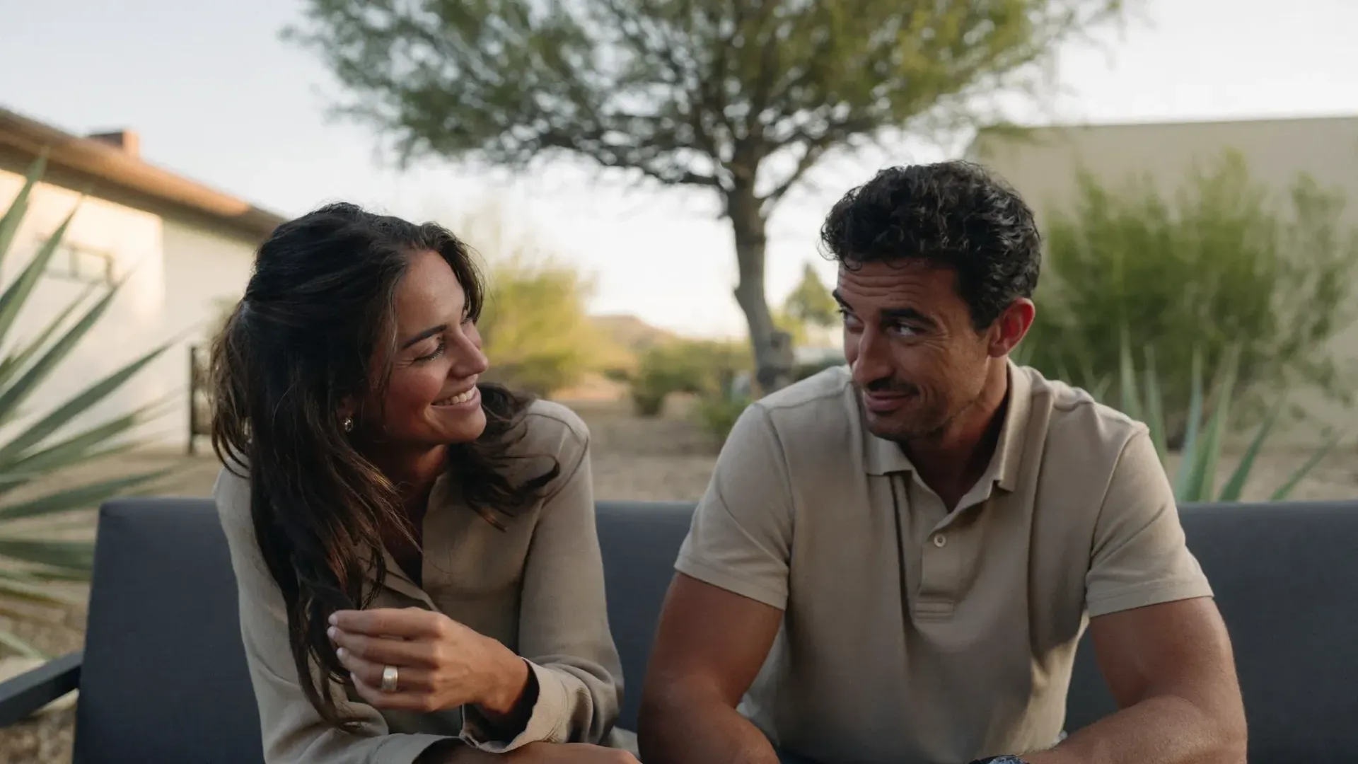 Married couple in their thirties sitting together outside at golden hour, talking, for couples counseling in Gilbert Arizona