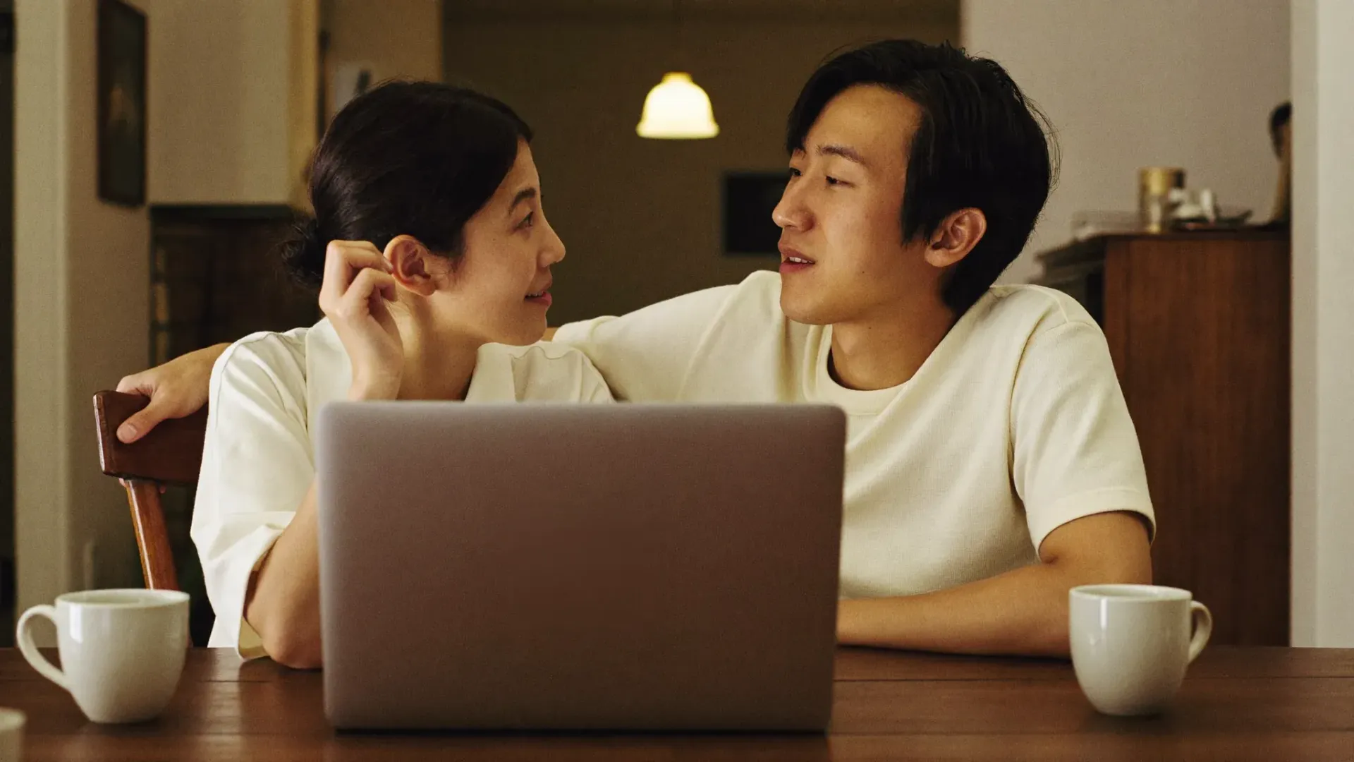 A married couple in Gilbert Arizona doing an online marriage counseling session together at their kitchen table in the evening
