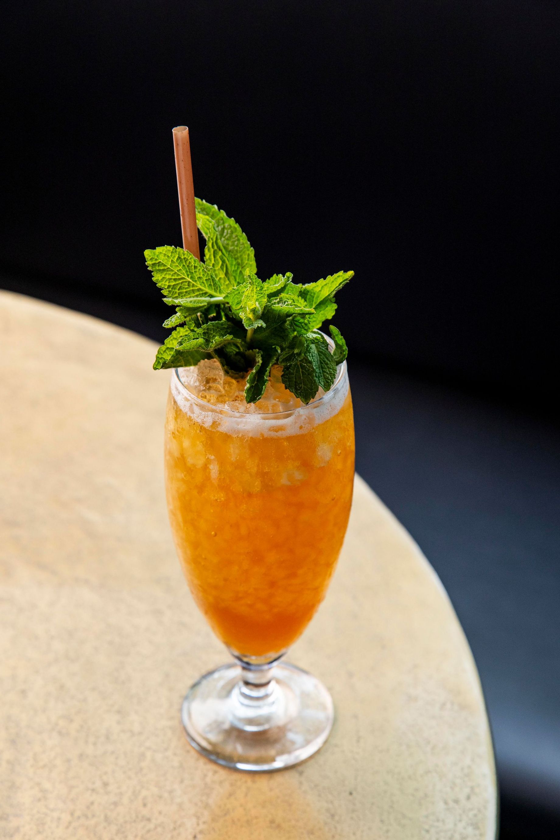 A close up of a drink in a glass on a table.