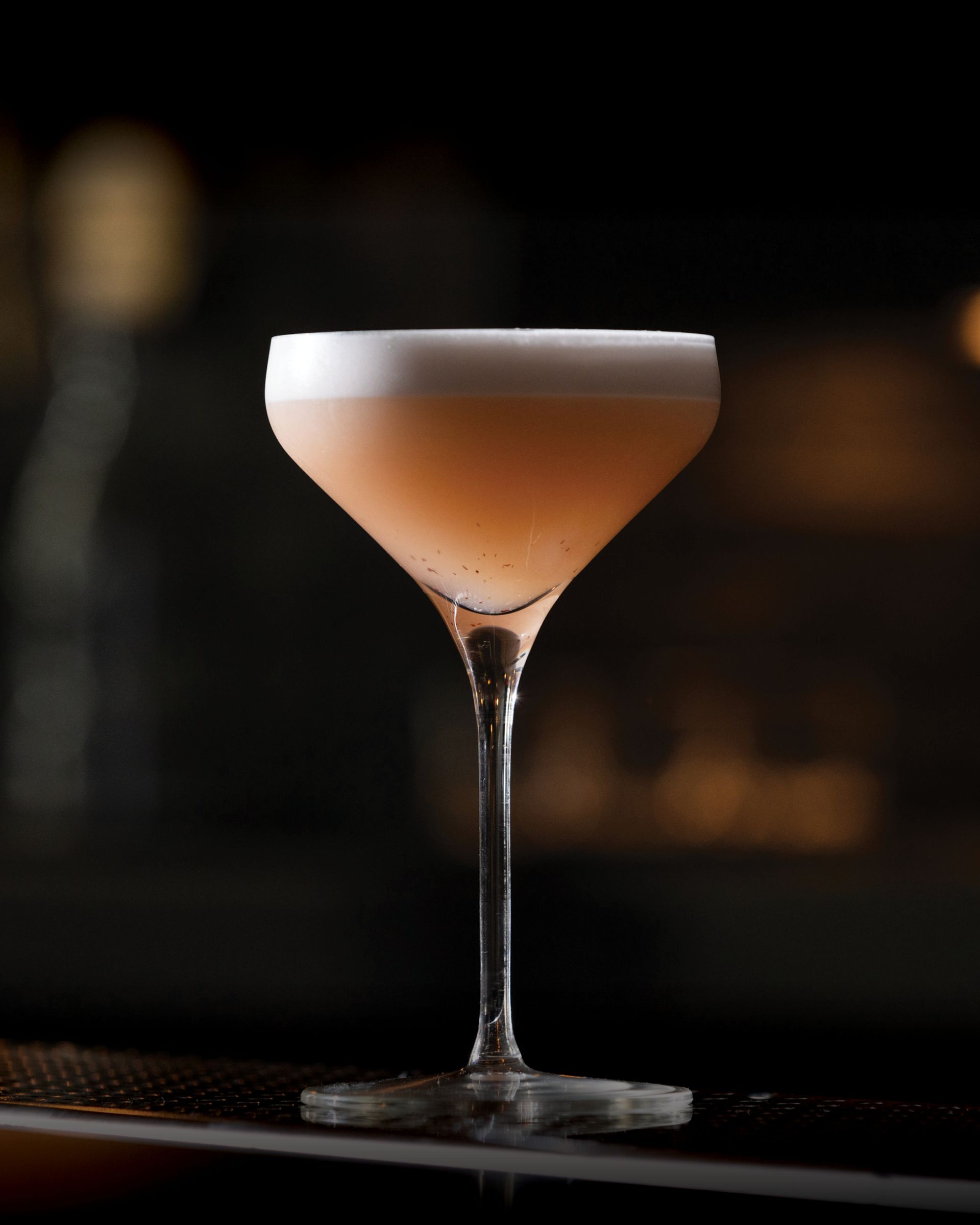 A close up of a cocktail in a martini glass on a bar