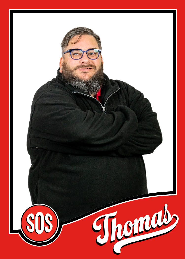 Thomas is the Account Specialist and is standing with his arms crossed.