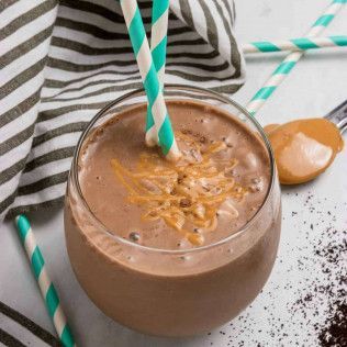 Chocolate peanut butter smoothie in a glass with straws and peanut butter drizzle.