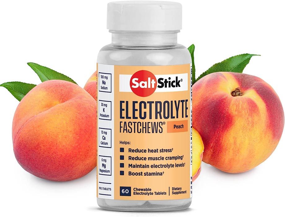 Bottle of SaltStick electrolyte chews (peach), with peaches and leaves.
