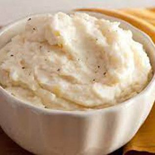 Bowl of creamy, mashed potatoes with black pepper.