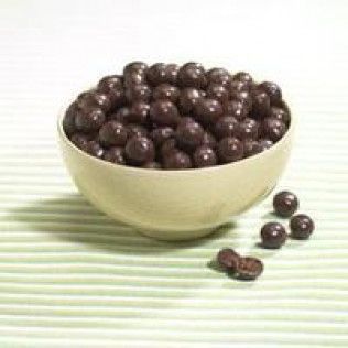 A bowl of dark chocolate-covered espresso beans on a striped surface.