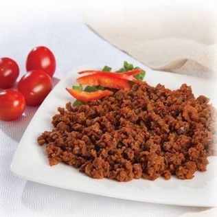 Ground meat seasoned on a white plate with tomatoes and pepper slices.