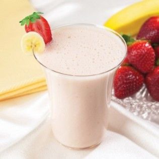 Strawberry banana smoothie in a glass, garnished with fruit.