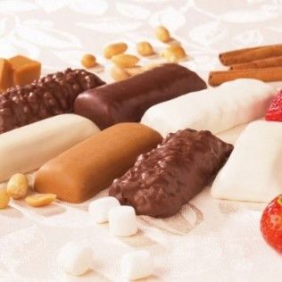 Assorted candies: chocolate-covered bars, peanuts, caramel squares, marshmallows, cinnamon sticks, and strawberries.