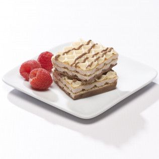 Two layered wafer squares with chocolate drizzle, next to three raspberries on a white plate.