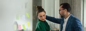 Man making woman uncomfortable in an office representing workplace harassment.