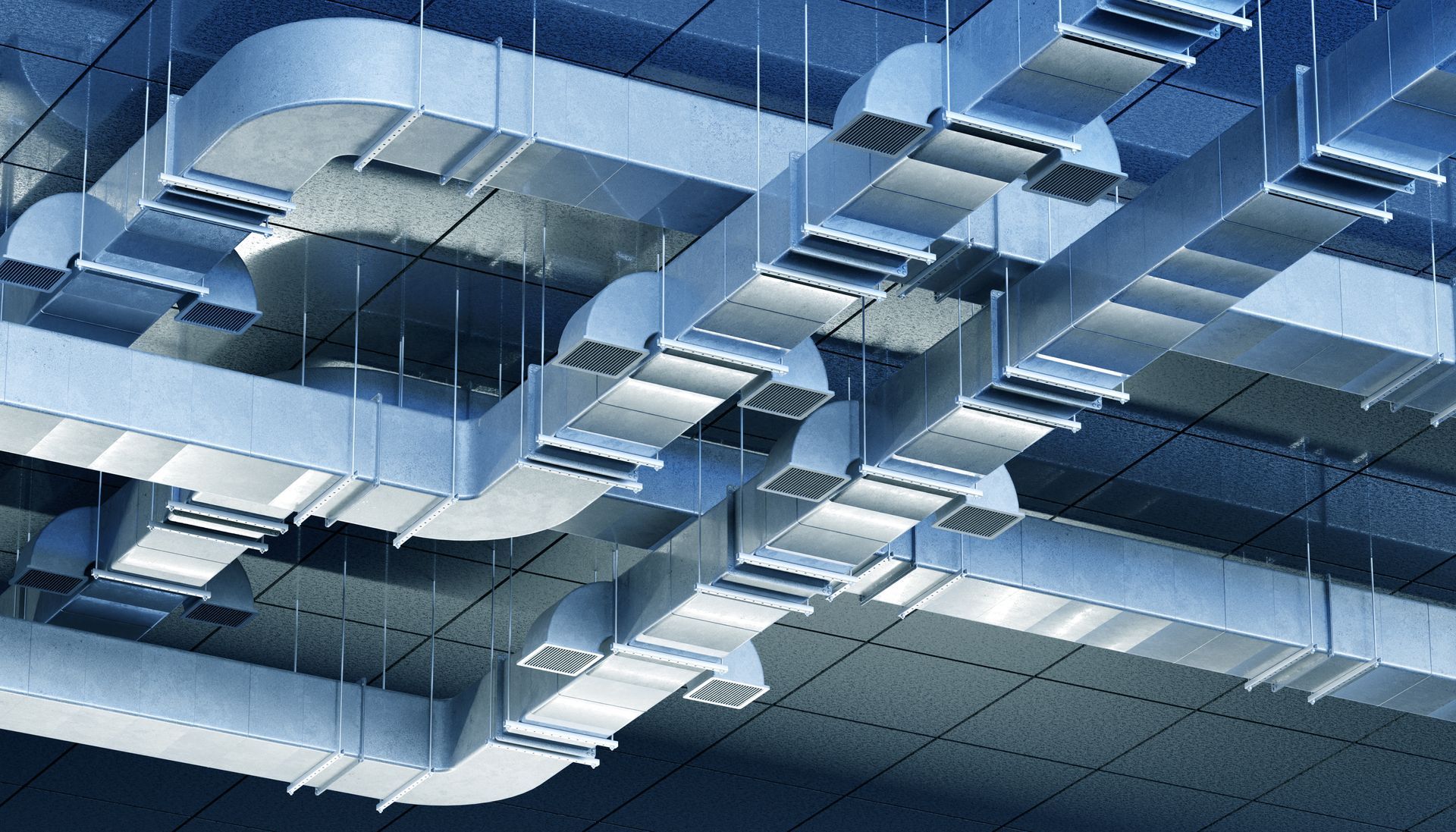 Blue-toned abstract ceiling with suspended rectangular panels and beams, lit by skylight-like reflections
