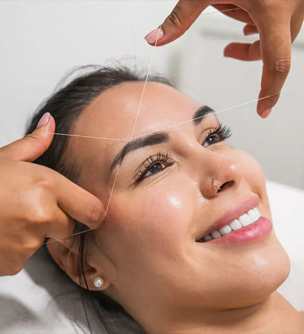 Beauty treatment with a thread lifting the skin on a smiling woman's face