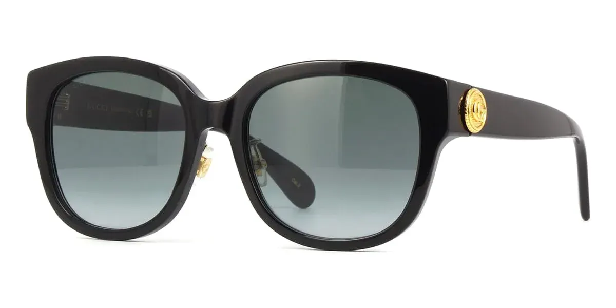 A pair of black sunglasses with a gold logo on the side on a white background.