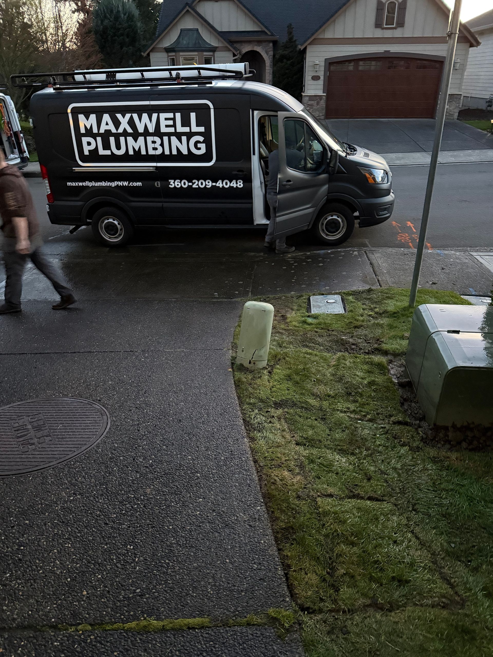Maxwell Plumbing truck with plumber getting ready to work. 