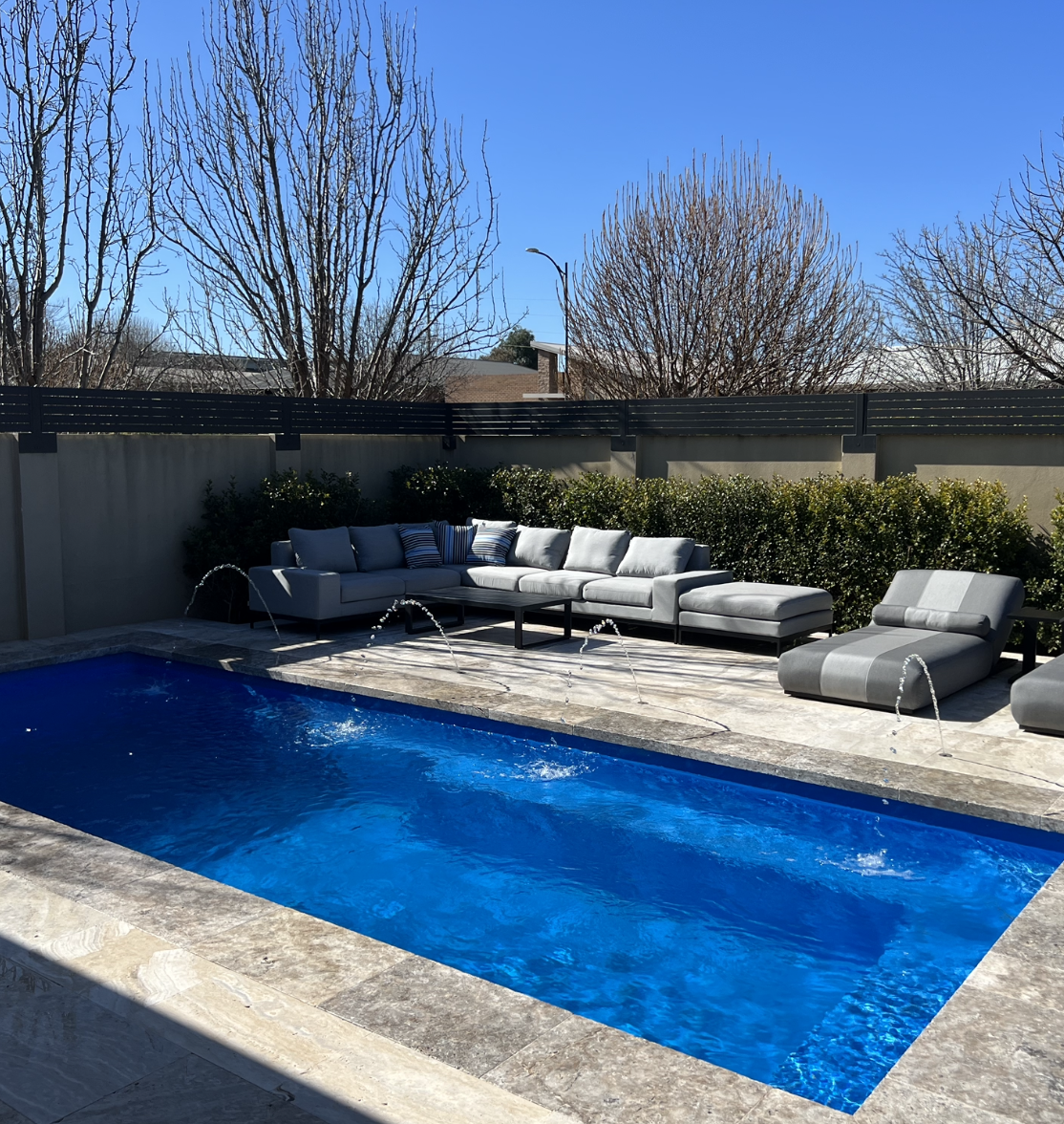 A Swimming Pool With chairs and deck jets — SJ Pools and Concreting in Parkes, NSW