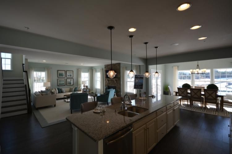 Open-concept living space with kitchen island, dining table, and living room in a modern home.