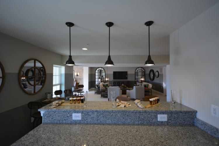 Kitchen island with granite countertop, pendant lights, and view into living room.