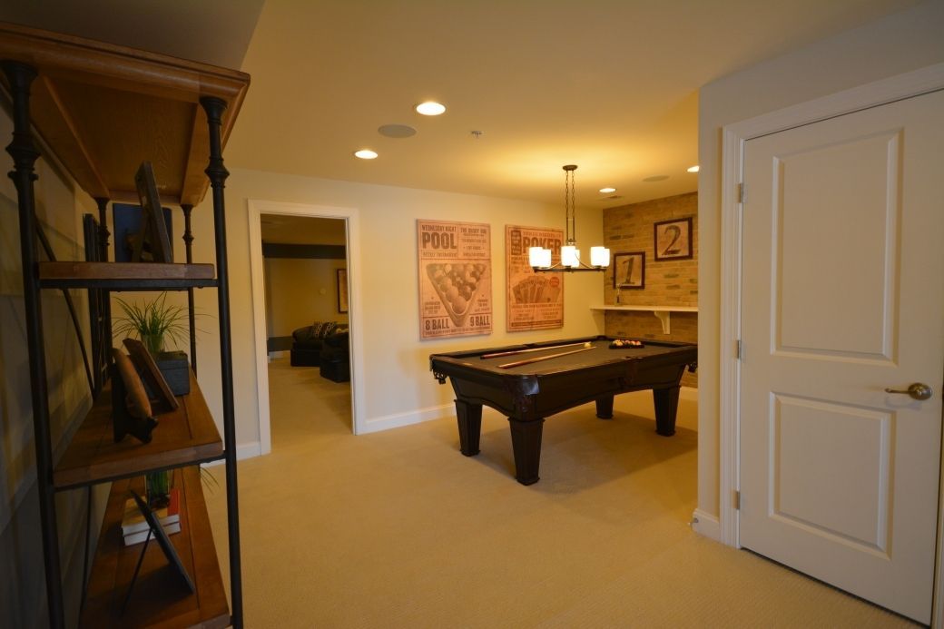 Game room with a pool table, artwork, and a bookshelf.