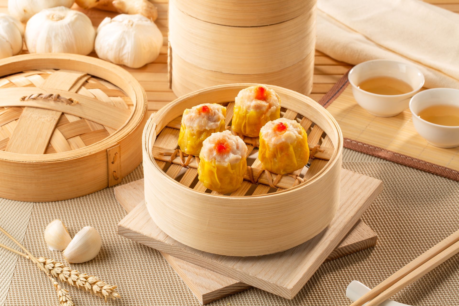 Four pieces of siu mai dumplings arranged neatly in a steamer