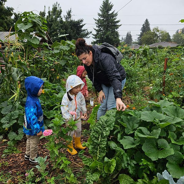 montessori guiden and children in a garden